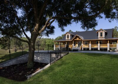 Rustic home with porch and large tree.