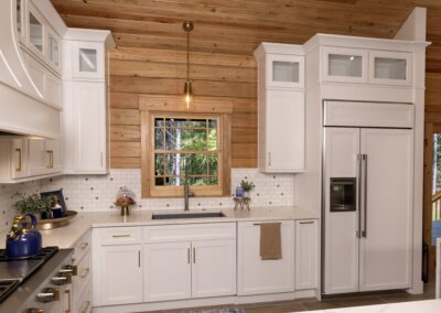 Modern kitchen with wood accents and white cabinets.