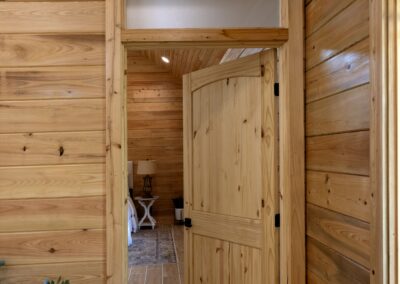 Wooden door opening to cozy bedroom interior