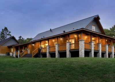 Wooden cabin with stone pillars at dusk