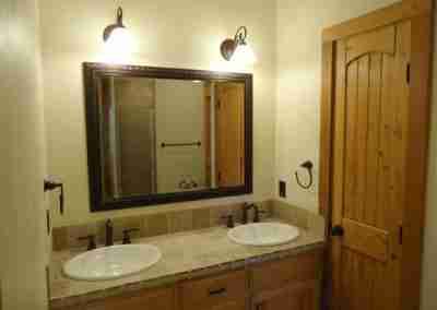 Elegant bathroom with double sinks and wooden accents.