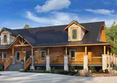 Modern log cabin with stone accents and porch.