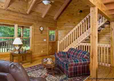 Cozy wooden cabin interior with plaid sofa.