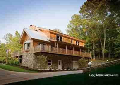 Beautiful log home with stone accents and balcony.