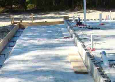 Construction site with concrete foundation and pipes.