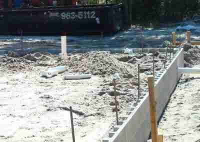 Construction site showing foundation preparation and materials.