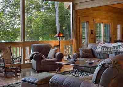 Cozy wooden living room with large windows.