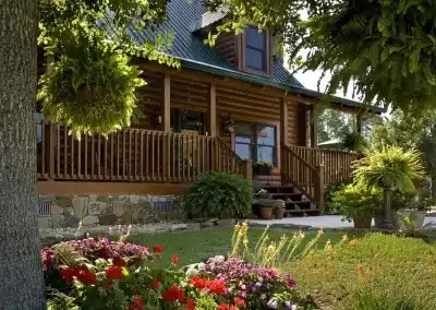 Charming log cabin surrounded by vibrant flowers.