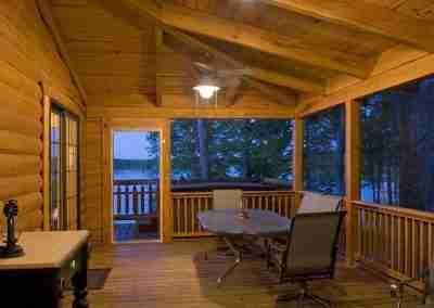 Cozy wooden porch with furniture and lake view