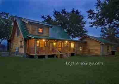 Cozy log cabin home with green roof at dusk.