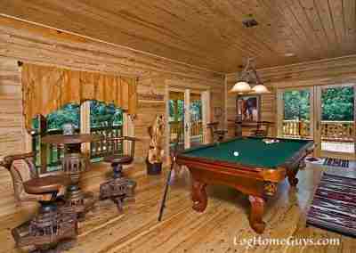 Cozy cabin game room with a billiards table.